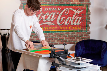One-color shirts are also printed on the portable V-100 tabletop press in-house (shown) and at offsite events.