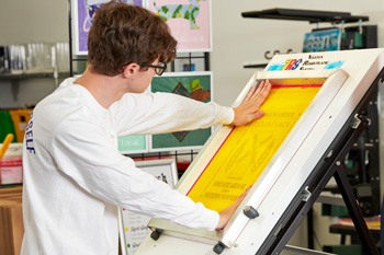 Using a PIN registration system, Brayden lines up positives in register before exposing the screens.
