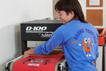 Garments are cured in the shop's compact infrared conveyor dryer, which is also used for off-site events.