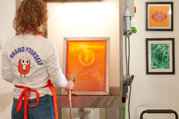 Screens are cleaned in the backlit washout booth for reuse.